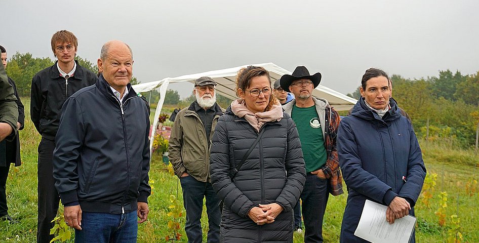 Dr. Olivia Kummel (re), Geschäftsführerin des LPV Potsdamer Kulturlandschaft, erläutert Altkanzler Olaf Scholz MdB (li) und Brandenburgs Landwirtschaftsministerin Hanka Mittelstädt MdL (Mitte) die Tätigkeit der Kooperative des LPV.