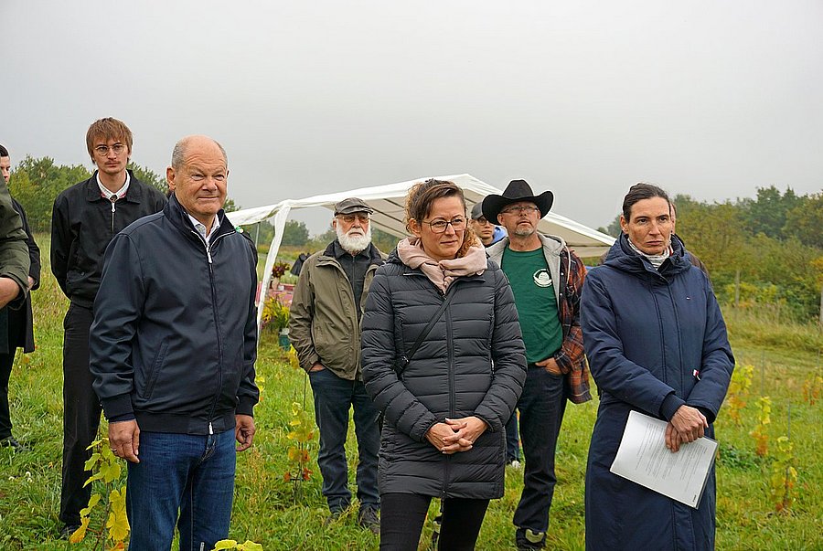 Exkursion im KoMBI-Projekt ©M. Stüber, DVL Dr. Olivia Kummel (re), Geschäftsführerin des LPV Potsdamer Kulturlandschaft, erläutert Altkanzler Olaf Scholz MdB (li) und Brandenburgs Landwirtschaftsministerin Hanka Mittelstädt MdL (Mitte) die Tätigkeit der Kooperative des LPV.